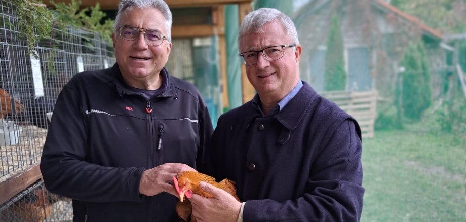 Vorsitzender Norbert Seibert und Bürgermeister Gerd Rocker mit Henne