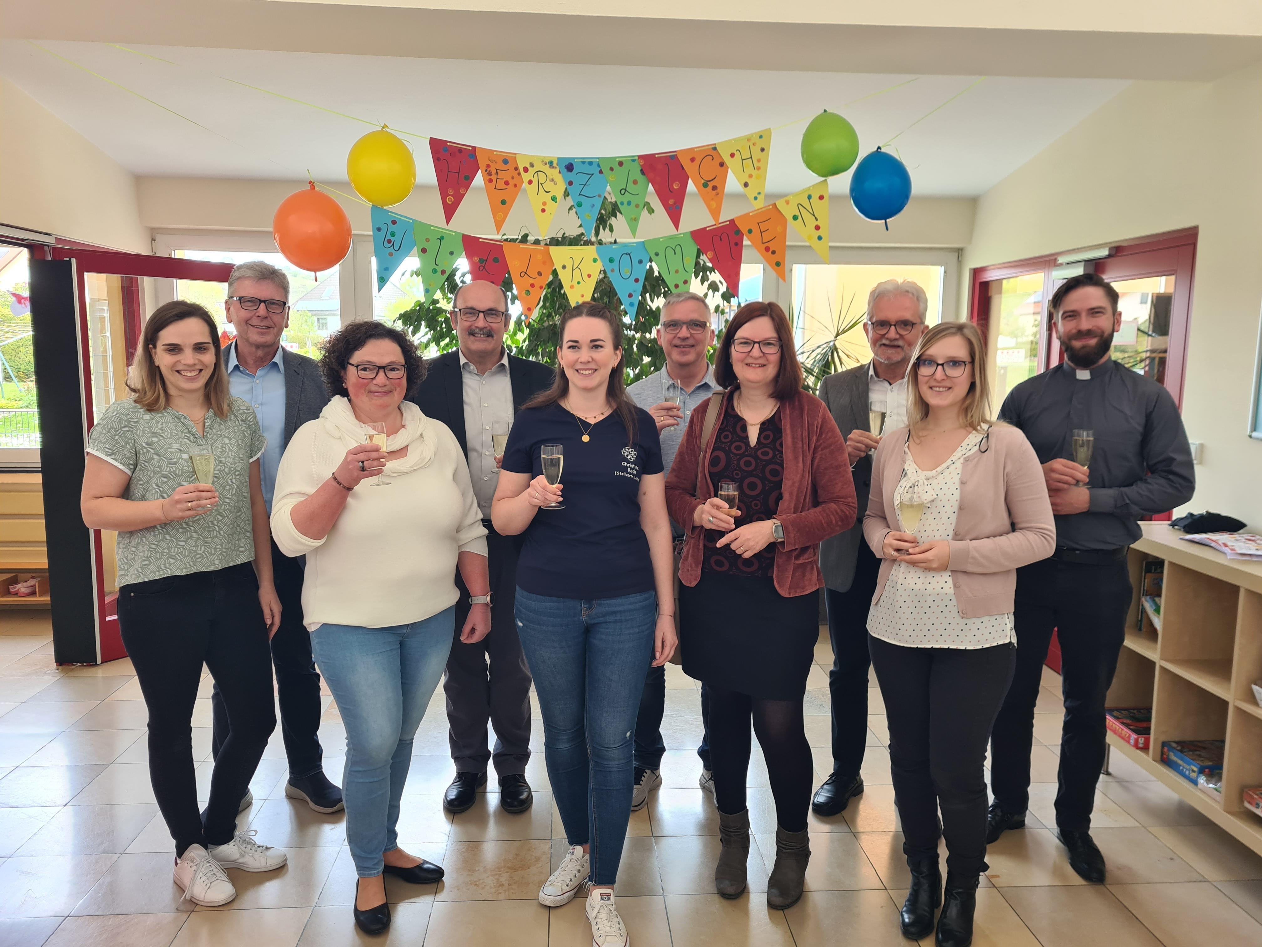 Ein Prosit auf den Anbau zur Kita Sonnenschein. Es freuen sich, vorne von rechts: Vanessa Schmitt (Jugendamt Kreisverwaltung Alzey-Worms), Anke Scherzer (ehemalige Leiterin der Kita), Christine Koch (kommissarische Leiterin), Susanne Schopp (neue Kita-Leitung ab Mai) und Carina Jacobs (Vorsitzende des Elternausschuss) zusammen mit (hinten von rechts) Pfarrer Johannes Mankel, Bauleiter Karl-Heinz Brück, Thorsten Jahn (Ortsbürgermeister Stein-Bockenheim), Jochen Emrich (Ortsbürgermeister Wonsheim) und Alfons Schnabel (1. Beigeordneter der Verbandsgemeinde Wöllstein).