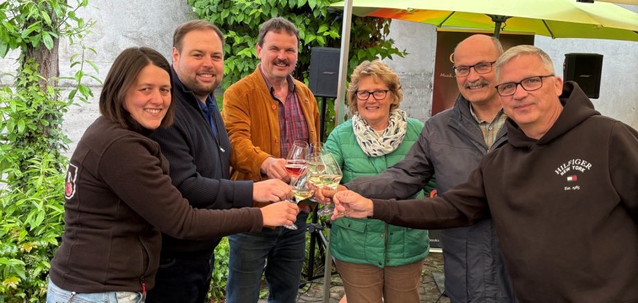 Auf die Eröffnung der Feieroomende stoßen Katharina Faust-Marchert, Bürgermeister Johannes Brüchert sowie Ortsbürgermeister Jürgen Vollmer, Annerose Kinder, Jochen Emrich, Thorsten Jahn gemeinsam an.